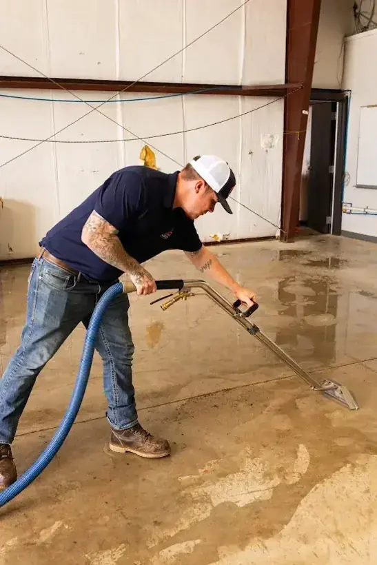 Extraction wand pulling water off a concrete floor during an Escondido dry-out