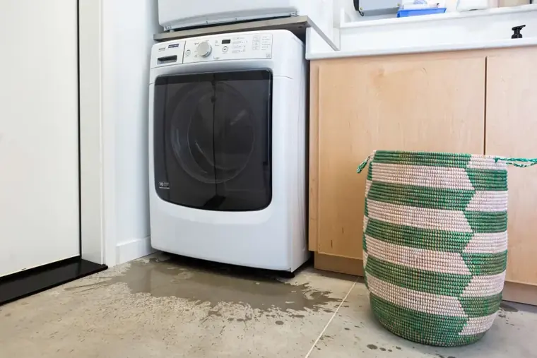 Water pooling on a laundry room floor from a washer supply line in Escondido