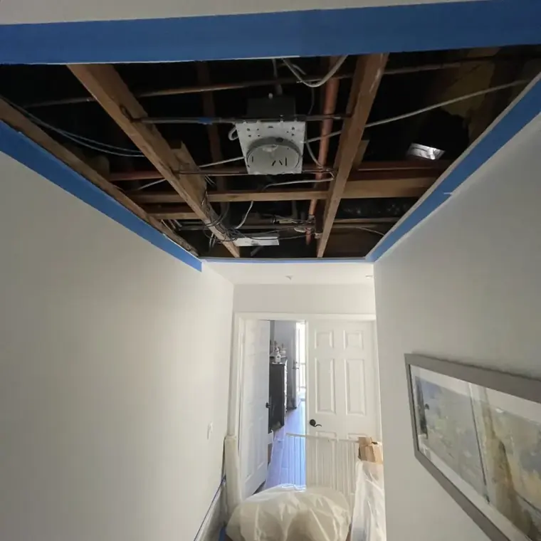 Wet ceiling drywall removed to open the joists in an Escondido hallway